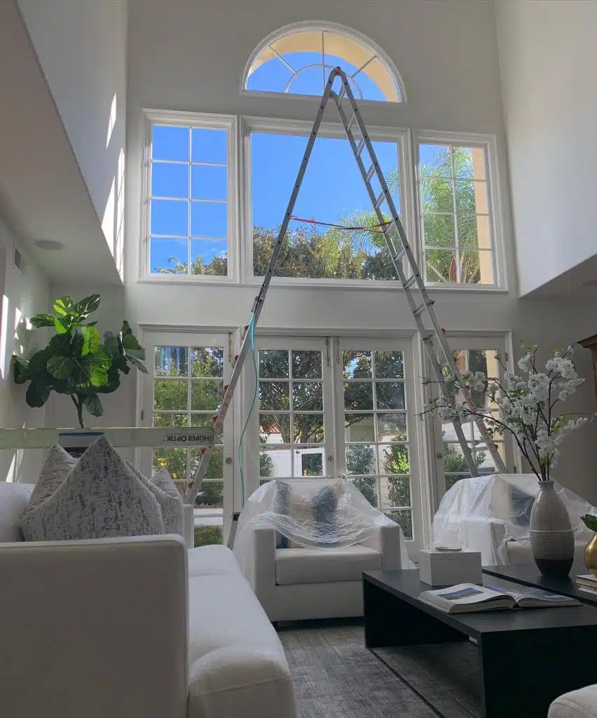 Residential window tinting installation in high-ceiling living room serving Huntington Beach, Newport Beach, Costa Mesa, and Laguna Beach