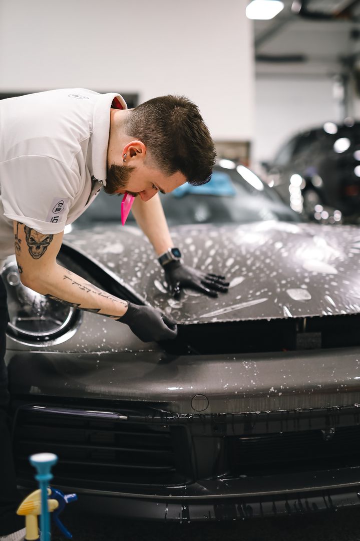 Paint protection film being installed on a black sedan hood at an Orange County detail shop